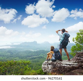 Backpackers on top of a mountain and enjoying valley view - Powered by Shutterstock