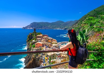 A backpacking girl looking at the stunning panorama of Vernazza on the Cinque Terre