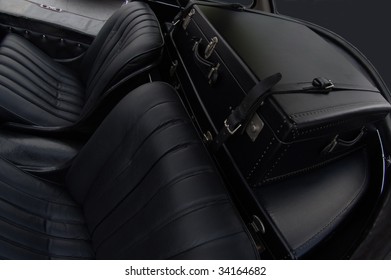 Backseat Of A Vintage Car With Retro Luggage In The Trunk