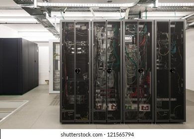 Backside Of Arranged Black Server Racks In Small Computer Room