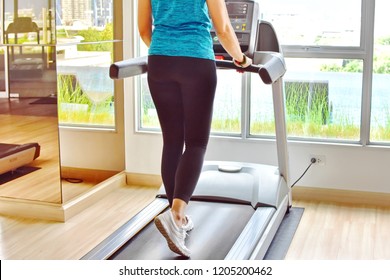 Backside Attractive Fit And Firm Woman Running On Treadmill On Exercise Machine At Gym With Pool And Natural View Outside, Health Care For Body Slim Improve Yourself New You For New Year Concept