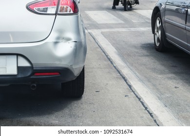 Backside of car has dented rear bumper damaged after accident on the road