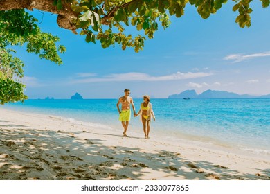 the backside of a couple of men and women sitting at the beach of Koh Kradan island in Thailand during vacation on a sunny day at holiday on the beach - Powered by Shutterstock