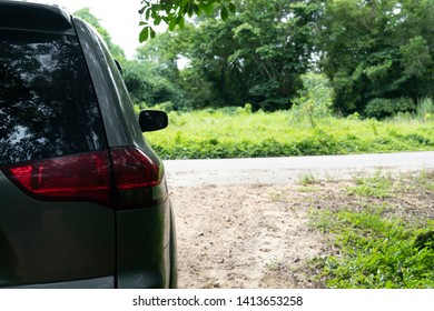 Backside of gray parked on the side of the road in nature