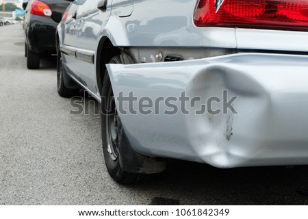 Backside of silver car get damaged by accident.