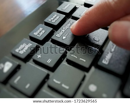 Backspace button on computer keyboard.  Selective focus on the word Backspace.  Copy space is on the left side.