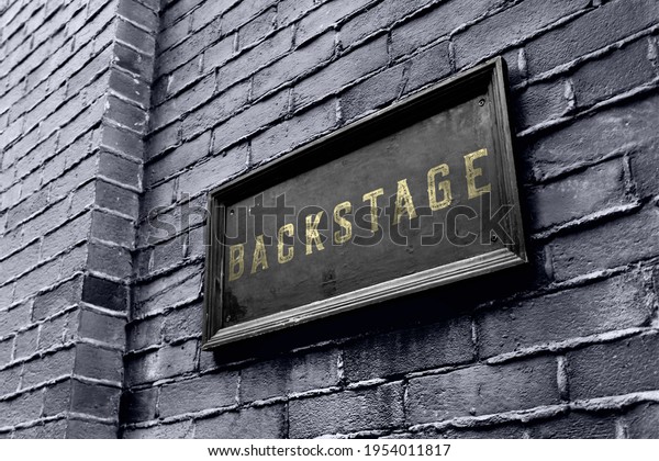 Backstage hanging signage wooden board.\
Business owner puts a golden black backstage\
sign.