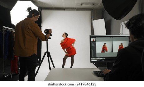 Backstage of model and professional team in the studio. Appealing woman posing for photographer, male editor looking at monitor checking photos. - Powered by Shutterstock