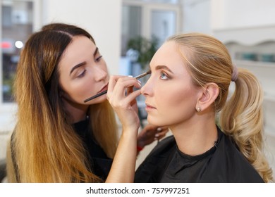Backstage photo as makeup artist applying eyeshadows for young woman in her studio - Shutterstock ID 757997251