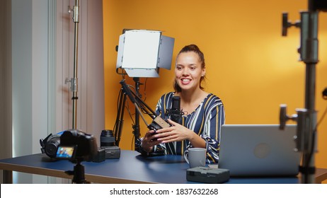 Backstage of vlogger recording to the camera tutorial about fluid heads in professional studio. Influencer making online internet content about video equipment for web subscribers and distribution