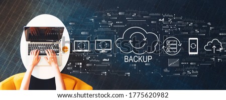 Backup concept with person using a laptop on a white table