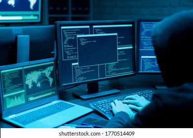 Backview of asian male hacker use computer to commit a crime