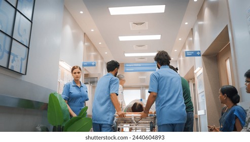 Backview Shot of Group of Medical Specialists Transporting an Elderly Patient with a Stretcher Through a Hospital Corridor. Health Clinic Receiving an Emergency Case for Intensive Care Unit - Powered by Shutterstock