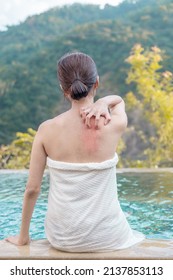 Backview of woman stratching her red back in the hotspring
