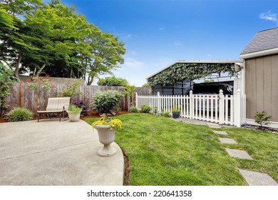 Backyard Area With Covered Parking Spot Separated With White Wooden Fence