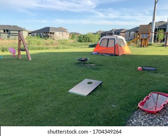 Backyard Camping In Town With Tent, Play Ground, And Fire Pit