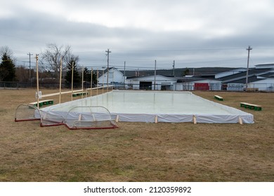 A Backyard Community Ice Surface Made From Plastic, Posts And Wooden Forms. The Center Is Covered In Water That Has Frozen Solid And Smooth For Ice Skating Or Hockey. The Winter Skating Rink Is Empty