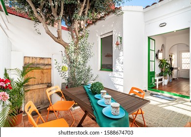 Backyard Cozy Patio Area With Tree And Furniture Set. View To The Patio And Interior Of House.