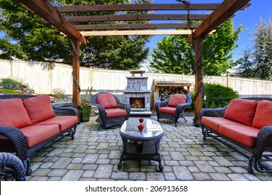Backyard cozy patio area with wicker furniture set and  brick fireplace
