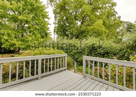 Backyard Deck Overlooking Lush Greenery And Trees.