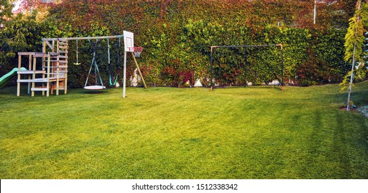 Backyard Garden Of A House With Children Playhouse, Basketball Hoop And Soccer Goal Post 