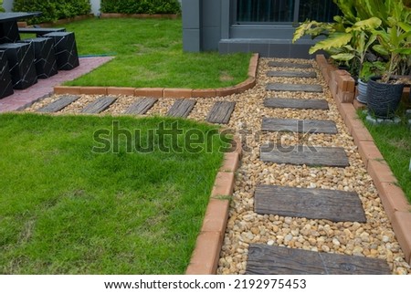 Backyard Garden Modern Design Landscaping. Landscaped Back Yard. Decorative Garden With Pathway Or Walkway From Stone And Rocks Or Gravel. Back Yard Or Park Lawn With Stony Natural landscaping.