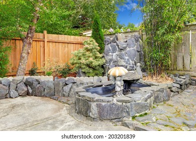 Backyard Garden With Rocky Fountain And Small Sculpture .