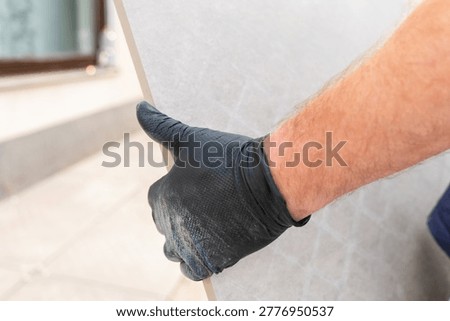  backyard improvement.Construction worker transporting a large tile slab for terrace flooring near residential building. professional tiling work. 