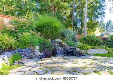 Backyard landscape with fountain and stone.