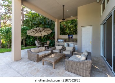 Backyard Of A Modern House With Swimming Pool, Artificial Grass, Trees, Chairs And An Umbrella.