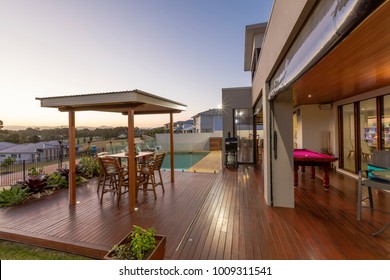 Backyard Patio Setting With Swimming Pool At Sunset In Luxury Home