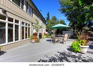Backyard patio with table set and jacuzzi. Patio decorated with flower pots