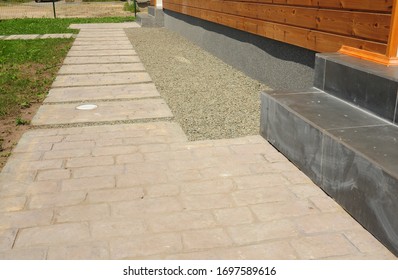 Backyard Sandstone Paving Walkway Near The House And Flowerbed.