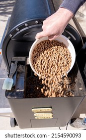 Backyard Smoker With A Pit Boss Pouring Hardwood Pellets In