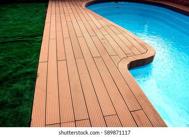 Backyard with swimming pool and composite material brown deck and blue water