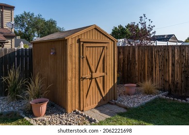 A Backyard Tool Shed With A Wooden Fence.