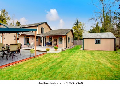 Backyard With Walkout Deck, Wood Pergola, Shed And Beautiful Green Lawn