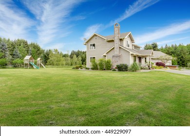 Backyard Well Kept Lawn. Playground With Swings, Climbing Wood Panel, Chute.