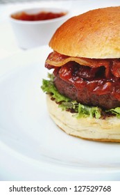 Bacon Burger On Plate With Relish In Background