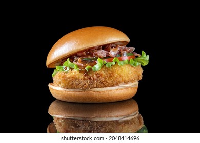 Bacon cheeseburger hamburger isolated on black. BBQ sauce and lettuce. Side view