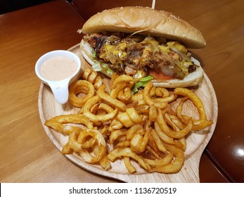 Bacon Cheeseburger :
The Melted Cheese Onto The Bacon With Curly Fries And Mayonnaise Sauce Served On 
Wooden Tray