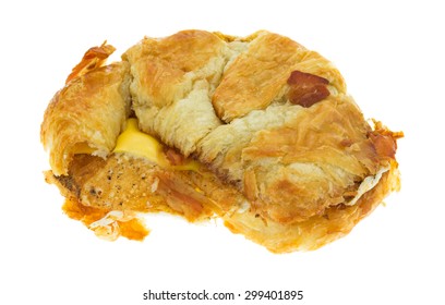 A Bacon Egg And Cheese Croissant Breakfast Sandwich With A Bit Of Bacon On The Crust Isolated On A White Background.