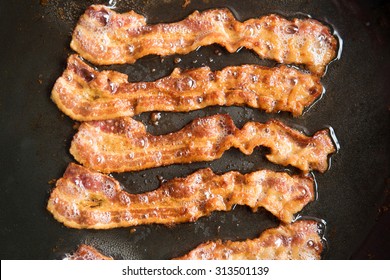 Bacon Strips Being Cooked In Frying Pan. Close Up. 