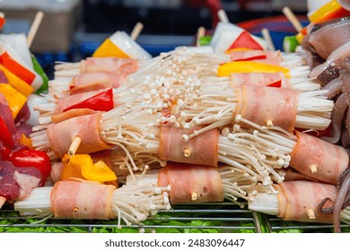 Bacon wrapped enoki mushrooms skewers. Thai strret food on night market. Asian food in Bangkok, Thailand. Japanese and Korean cuisine - Powered by Shutterstock