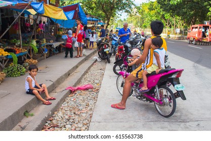 Bacong, Philippines: 26 June, 2016: Big Family On Pink Motorbike By  Local Market. Asian Food Market With Local People From Village. Philippines Poor Children. Simple People Everyday Lifestyle Routine