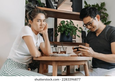 Bad asian couple date of man addicted to mobile game and woman gets mad.