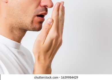 Bad breath. Halitosis concept. Young man checking his breath with his hand. - Shutterstock ID 1639984429