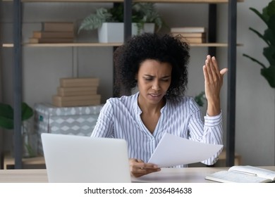 Bad business letter. Distressed worried young african businesswoman read bad news about insolvency bankruptcy in official paper document. Nervous black female employee get debt notification from bank