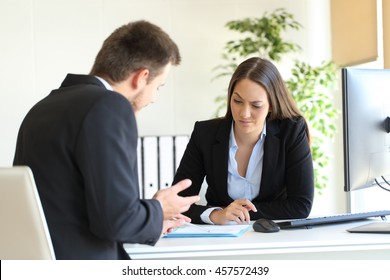 Bad Businessman Trying To Convince To A Suspicious Client During A Difficult Negotiation In A Desktop At Office