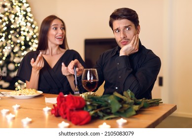Bad Date Concept. Young Millennial Couple Having Unsuccessful Blind Date In Restaurant, Funny And Handsome Disappointed Shoked Man Feeling Embarrassment Listening To Excited Woman Talking